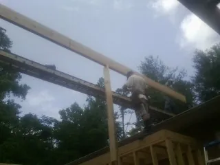 Carpenter setting a ridge beam over a new addition frame — Ice Dam Removal by Roofing Brothers in Excelsior