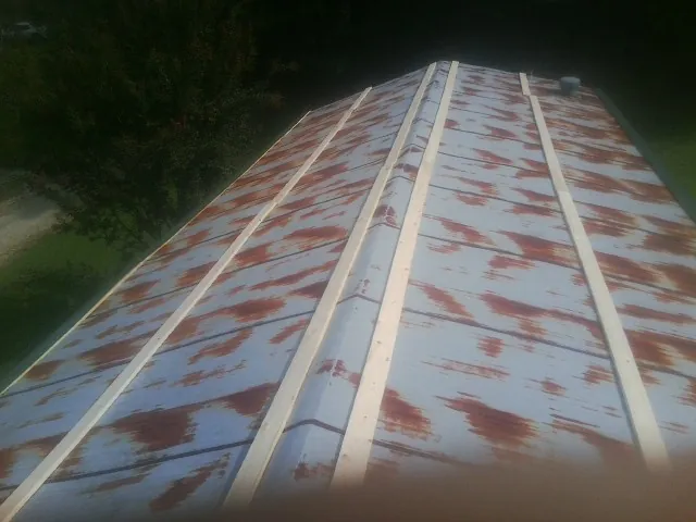 Rusted metal roof panels with new wood purlins before replacement — Storm Damage Roof Repair in Excelsior by Roofing Brothers