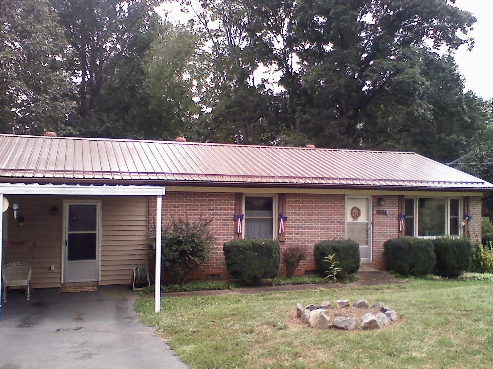 Bronze metal roof and carport on a brick ranch home — Roof Repair work by our crew in Excelsior
